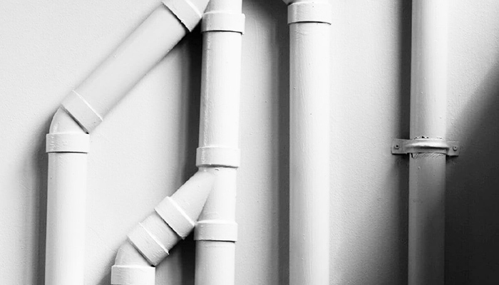 four pipes attached to the wall painted in white